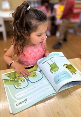 Lyonsgate Montessori School Casa student reading a French book.