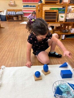 Lyonsgate Montessori School Casa student working with the Montessori Geometric Solids material.