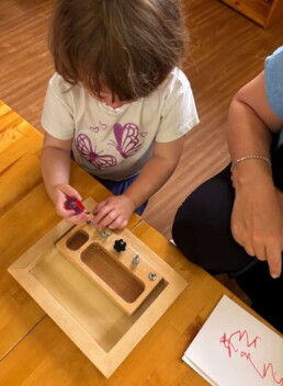 Lyonsgate Montessori School Toddler student building motor skills and hand strength and dexterity by working with various fasteners and tools.