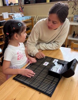 Lyonsgate Montessori School Casa student building reading skills with the Montessori Phonetic Cards material.