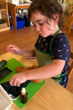 Lyonsgate Montessori School Casa student working with the Montessori Polishing Wood activity, one of a number of increasingly complex polishing activities, after receiving a presentation of it.