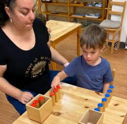 Lyonsgate Montessori School Casa student receiving a presentation with the Montessori Sound Boxes material to develop auditory discrimination.