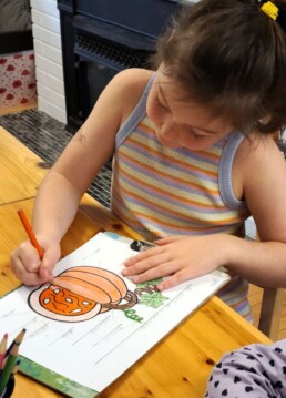 Lyonsgate Montessori School Elementary student colouring the parts of a pumpkin.