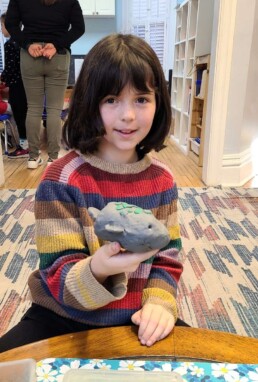 Lyonsgate Montessori School Elementary student with a model of a marine mammal.