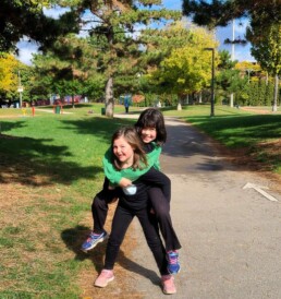Lyonsgate Montessori School Elementary students piggybackin' at the park on a warm fall day.