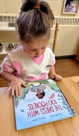 Lyonsgate Montessori School Casa student sitting down to enjoy a book.