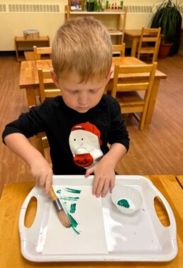 Lyonsgate Montessori School Toddler student exploring how a paintbrush can make different textures and working on his wrist motion.