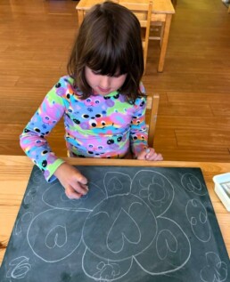 Lyonsgate Montessori School Casa student enjoying some creative art work with chalk.