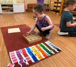 Lyonsgate Montessori School Casa student working with the Montessori Colour Box 3 material to develop visual discrimination between shades of colours.