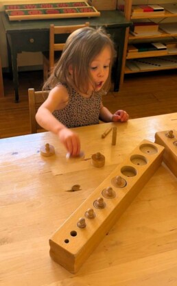 Lyonsgate Montessori School Casa student working with the Montessori Cylinder Blocks material.