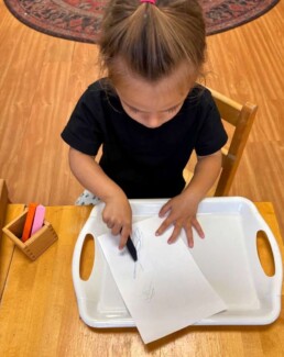 Lyonsgate Montessori School Toddler student drawing for both fun and to develop handwork coordination.