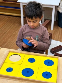 Lyonsgate Montessori School Casa student exploring the Montessori Geometry Cabinet material.