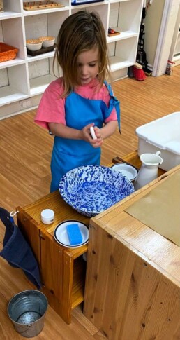 Lyonsgate Montessori School Casa student engaged in the Washing Hands and Nails Montessori activity.