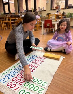 Lyonsgate Montessori School Casa student receiving a presentation with the Montessori Large Number Cards material.