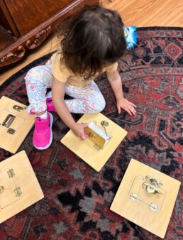 Lyonsgate Montessori School Toddler student working with locks and latches to develop motor and problem solving skills.
