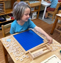 Lyonsgate Montessori School Casa student undertaking the big task of identifying and placing numbers to 100.