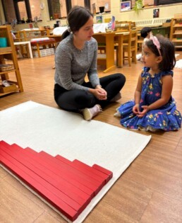 Lyonsgate Montessori School Casa student receiving a presentation with the Montessori Red Rods material.