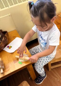 Lyonsgate Montessori School Toddler student rolling playdough.