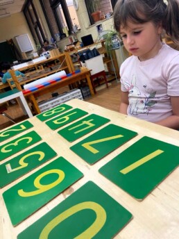 Lyonsgate Montessori School Casa student working with her French classroom assistant on French numbers with the Montessori Sandpaper Numbers material.