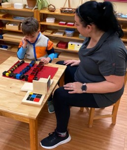 Lyonsgate Montessori School Casa student receiving a presentation of the Montessori Trinomial Cube material -- a puzzle to recognize patterns and relationships in Casa and used again to learn algebraic concepts in Elementary.