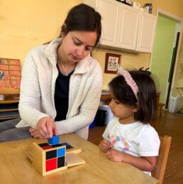 Lyonsgate Montessori School Casa student receiving a presentation of the Montessori Binomial Cube material.