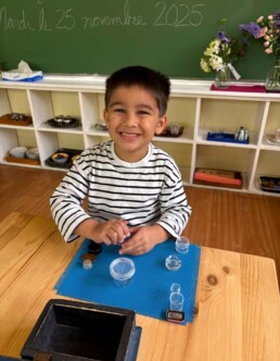 Lyonsgate Montessori School Casa student working at the Montessori Boxes and Bottles activity that helps build the hand strength and dexterity needed for later handwork such as writing and other hand work.