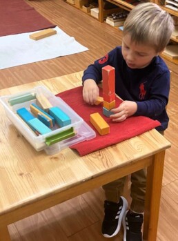 Lyonsgate Montessori School Casa student building with blocks that are magnetic so the poles have to be placed correctly.