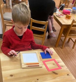 Lyonsgate Montessori School Casa student working with the iconic Metal Insets Montessori material.