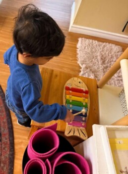 Lyonsgate Montessori School Toddler student enjoying time with the classroom's new fish xylophone.