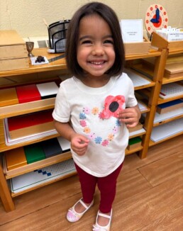 Lyonsgate Montessori School Casa student proudly showing the poppy she made on Remembrance Day.