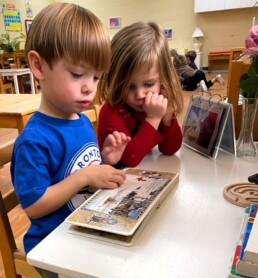 Lyonsgate Montessori School Casa students enjoying a book together.