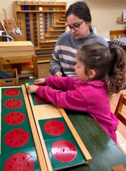 Lyonsgate Montessori School Casa student receiving a presentation with Small Metal Insets, a material that is revisited in the Elementary program to learn about fractions.
