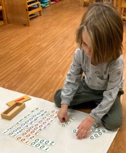 Lyonsgate Montessori School Casa student learning about numbers into the thousands with the Montessori Small Number Cards material.