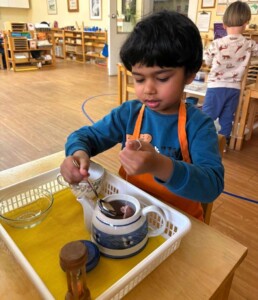 Lyonsgate Montessori School Casa student learning to follow the steps to make tea.