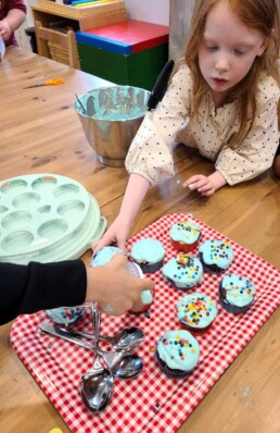A Lyonsgate Montessori School Elementary students decorating cupcakes for their charity outreach project fundraising sale.