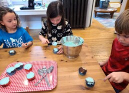 Lyonsgate Montessori School Elementary students icing cupcakes for their charity outreach project fundraising sale.