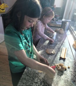 Lyonsgate Montessori School Elementary students making sugar cookies; baking activities involve hand work and practical applications of math and art.