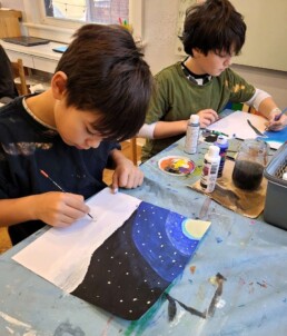 Lyonsgate Montessori School Elementary students painting winter landscapes with acrylic paint.