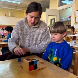 Lyonsgate Montessori School Casa student receiving a presentation of the Montessori Binomial Cube material, which is a puzzle that builds pattern recognition at this age and a reference for cubing and early algebra work later.