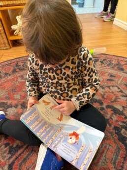 Lyonsgate Montessori School Toddler student looking at a book.