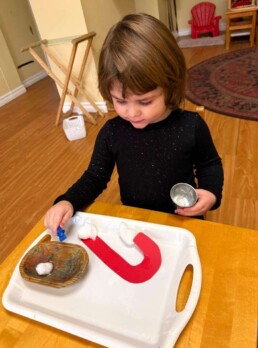 Lyonsgate Montessori School Toddler student putting Pasting practice to use while working on a candy cane craft.