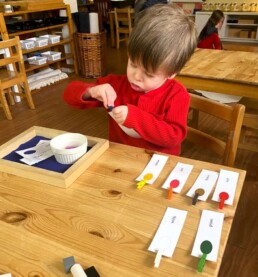 Lyonsgate Montessori School Casa student identifying colours and building vocabulary and fine motor skills.