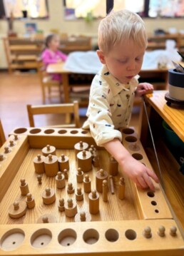 Lyonsgate Montessori School Casa student working with four different Montessori Cylinder Block materials at the same time.