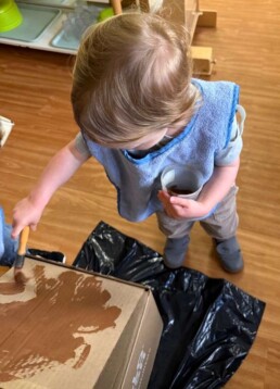Lyonsgate Montessori School Toddler student painting a 