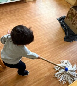 Lyonsgate Montessori School Toddler student bringing energy and passion to mopping the classroom floor.