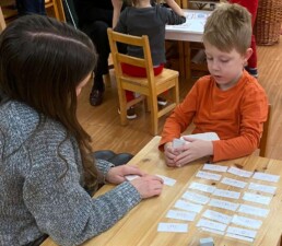 Lyonsgate Montessori School Casa student practicing reading with Montessori Classified Cards.