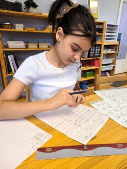 Lyonsgate Montessori School Elementary student working to solve money-based word problems.