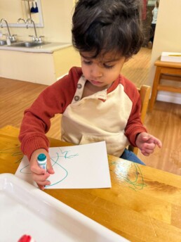 Lyonsgate Montessori School Toddler student building creative expression with markers.