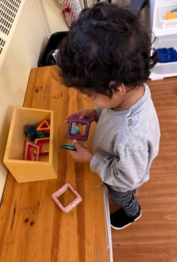 Lyonsgate Montessori School Toddler student discovering the new magnetic geometric shapes material introduced to the class for the new term.