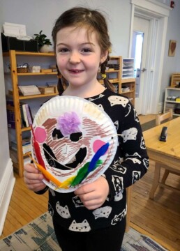 Lyonsgate Montessori School Elementary student with a theatre mask made as part of their ancient Greek studies.